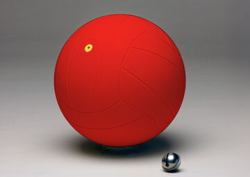 Ansicht auf den roten Ball. Davor liegt eine kleine silberne Rassel.