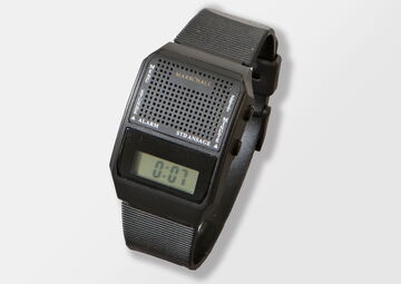 Ansicht auf die schwarze Uhr mit Display in einem transparenten Ständer.